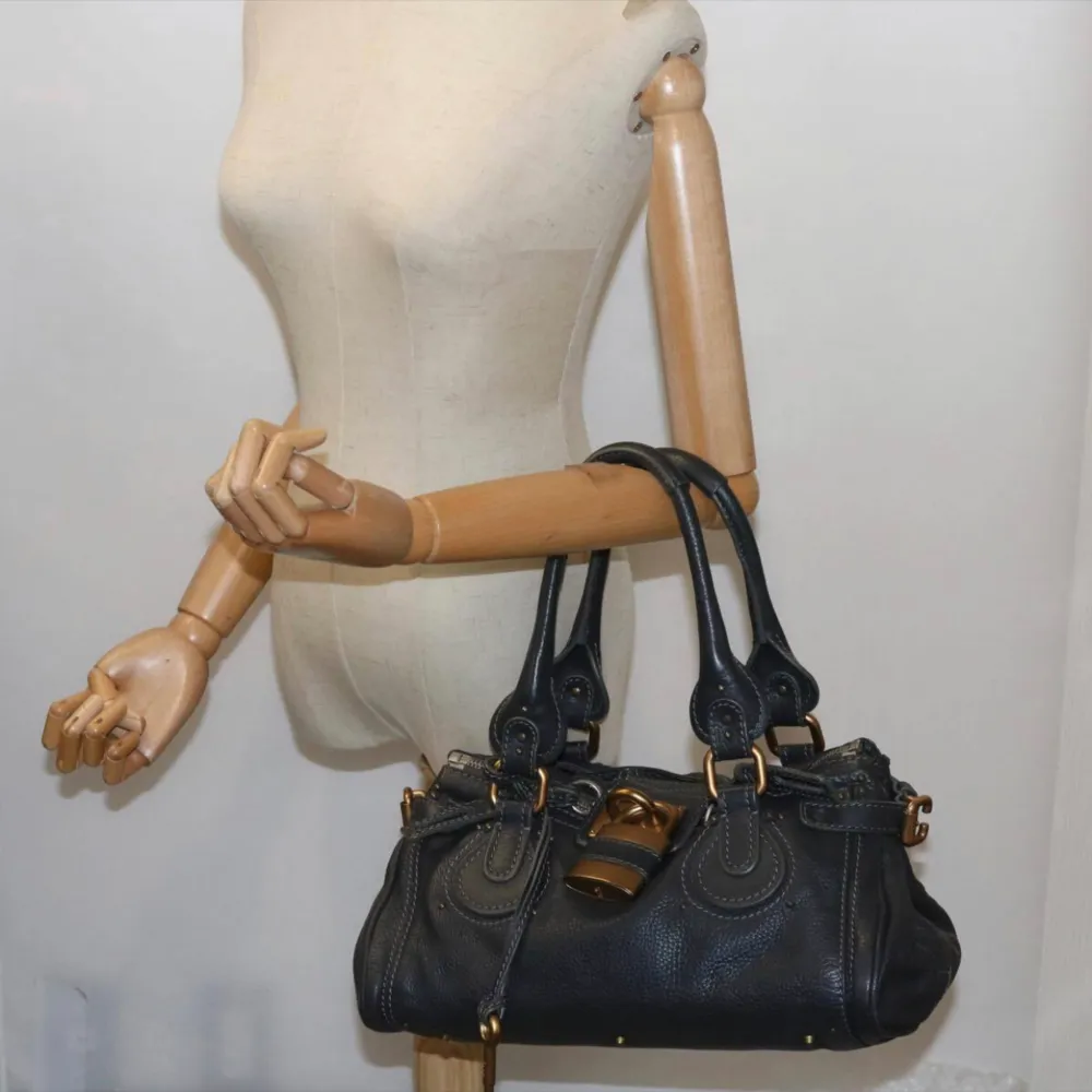 Chloé Paddington-väska i härligt svart läder. Väldigt cool väska!! Mest känd från 2000-talet. Lämplig för dagligt bruk och utomhus.  Fler bilder och mer info i vår webbutik vintagetreasures.co. Väskor.