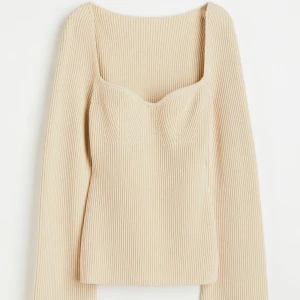 H&M ribbstickad tröja - Figurnära ribbstickad tröja med hjärtformad ringning och långa utställda armar. Använd ett fåtal gånger, som ny. Nypris: 399