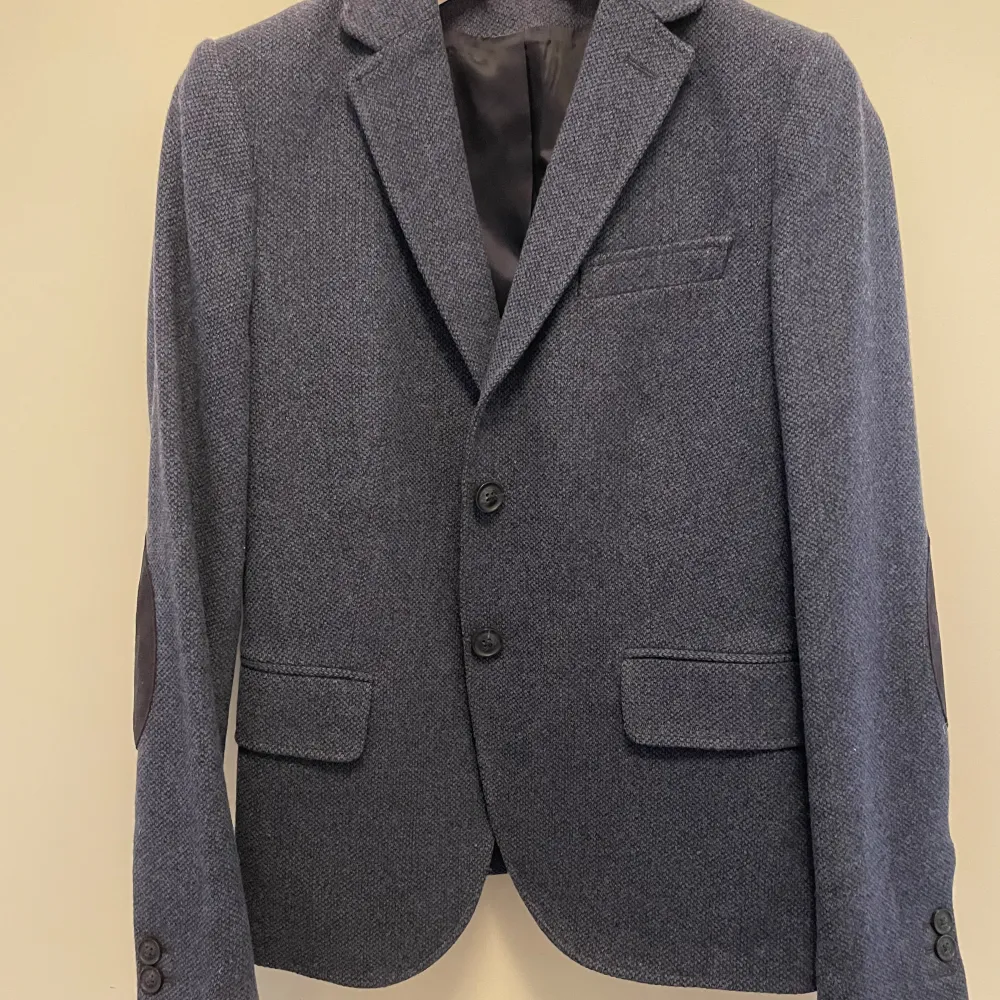 GANT kavaj i blå ull (80%) och polyamid (20%). Använd endast en gång. Storlek 36. Köpte den för 2 895 kr och säljer för 2 000 kr.. Kostymer.