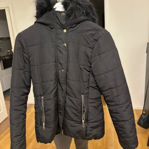 Svart jacka med luva - Svart jacka med dragkedja och fluffig luva. Storlek 34. Köparen står för frakten💕