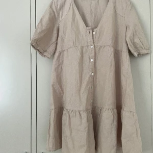 Klänning - Beige klänning. Helt ny bara testad. Klänningen kom med en fläck över ena knappen. Inte jätte synlig. Strl xs
