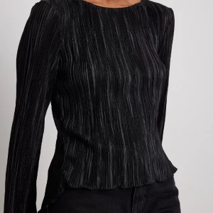 Långaramd topp - Från NA-KD, ny pris 399kr. Aldrig använt den, topp med snörning i ryggen.