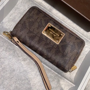 Michael kors plånbok  - Köpt i USA. Äkta Michael kors, ifrån Michael kors butik. Använd (lite repor på själva märket, annars ingen skada) 