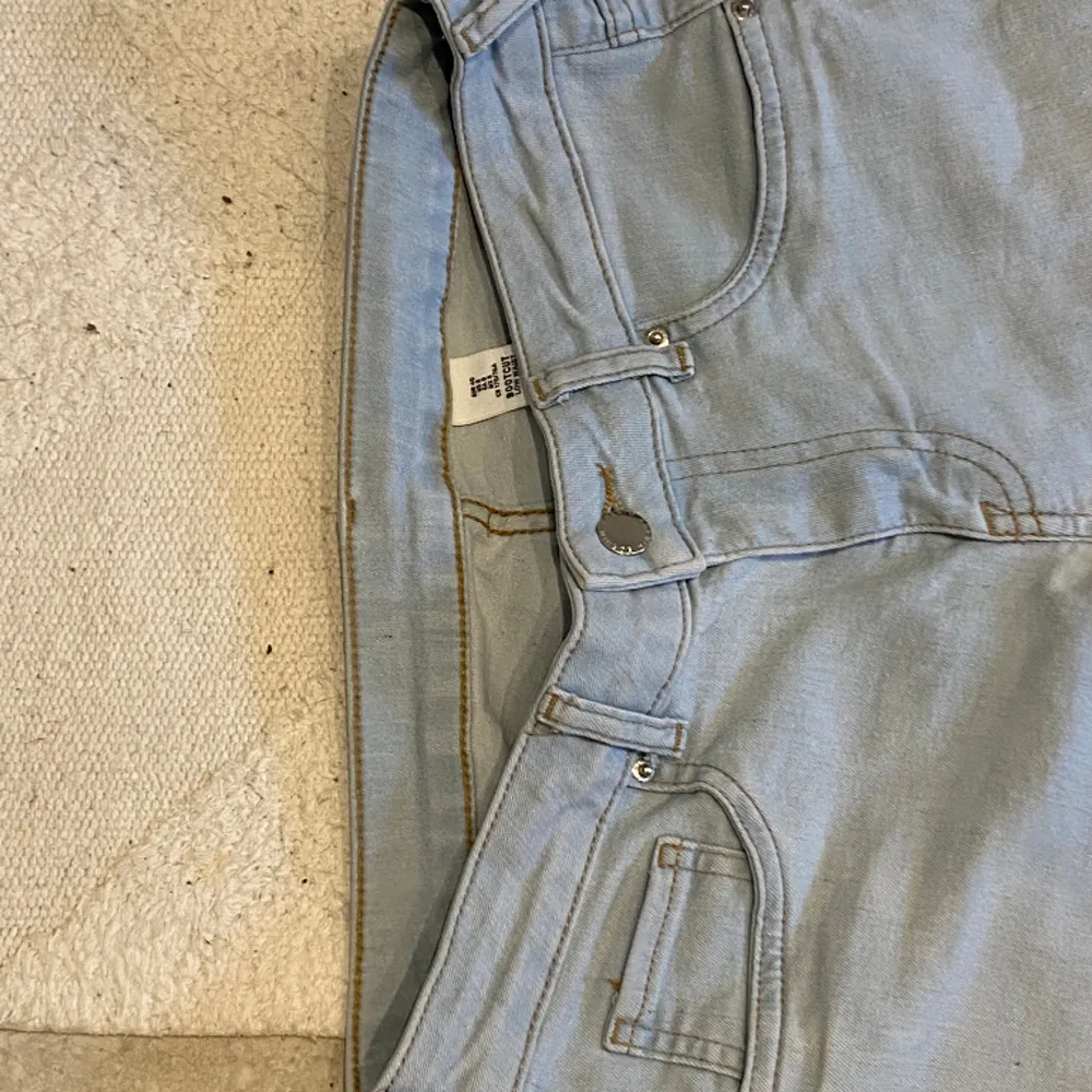 Ljusblåa bootcut jeans. Har använts ett par gånger och tyvärr fått en liten fläck, där det blåa har suddats bort lite. De är i bra skick, om man tänker bort fläcken. Är i storlek 40 men kan också användas som 38. Midjemått 37 och innerbenslängden 77. Jeans & Byxor.