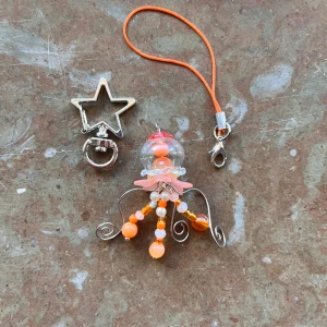 Orange manet 🧡🪼 - En liten manet där du kan välja att ha som en nyckelring eller en phonecharm!⋅˚₊‧ ଳ⋆.ೃ࿔*:･  Med en nyckelring kostar det 5kr extra!   Maneten har glas komponenter så var försiktig! <3  Skriv i DM först, tack! ༊彡