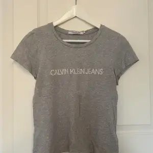 Säljer nu min gråa Calvin Klein t-shirt. Inga defekter. Nypris 299kr säljer för 50kr. Figursydd XS men passar även en S
