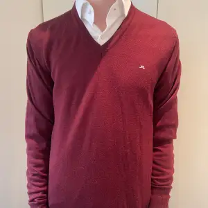 V ringad merino tröja från J.Lindberg i storlek M. Snygg vinröd färg i jätte bra skick. 