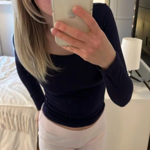 Mörkblå Långärmad tröja - Långärmad tröja i bomull. I färgen mörkblå. U-rigning och tight passform. Använd ett fåtal gånger och är i jättefint skick. Storlek XS.💗