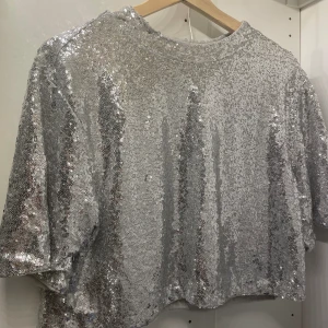 Glittertopp - Passar snyggt med ett vitt linne eller spetsduken under, fint skick, aldrig använd 