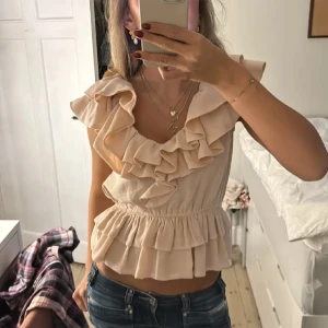 H&M topp - populär Volangblus från h&m! Lappen i tröjan är bortklippt men skulle säga att storleken är S! 