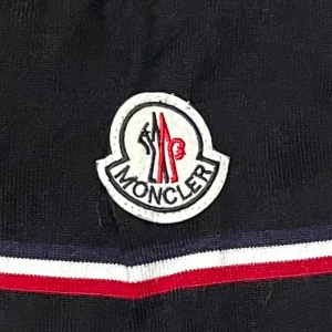 Moncler- tröja - Säljer denna svarta v-ringade tröja ifrån Moncler i bra skick, eftersom det inte är något som jag använder. Det är i barnstorlek XL, vilket passar S/M