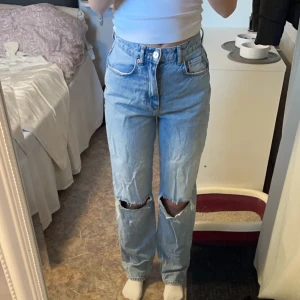 Jeans med hål  - Högmidjade jeans med hål i knäna. Hålen kan vara lite större än när dom köptes