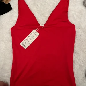 Röd body - Röd body, aldrig använd.  Storlek S, passar även XS.