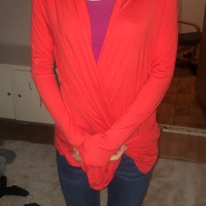 En röd kofta - En röd kofta utan dragkedja med fickor 