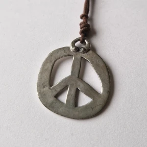 Halsband fredsmärke - Halsband med läderrem och handsmitt hänge! Säljer då det inte används. 