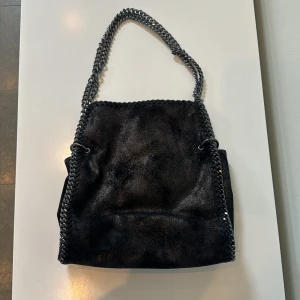 Väska  - Väska i gott skick, okänt märke. Köpte för 350kr säljer för 120kr. Svart med glitter.