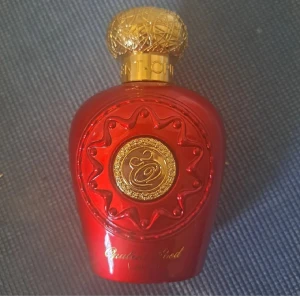 Opulent Red Lattafa Perfumes - Opulent Red från Lattafa är en parfym för både kvinnor och män. Flaskan är röd med en dekorativ guldlock. Parfymen har en rik och komplex doftprofil med huvudnoter av tuberos, jasmin, heliotrop, brasilianskt rosenträ och cognac. Basnoterna inkluderar agarwood (oud), vanilj, amber, sandelträ, tonkaböna, patchouli och cashmeran.