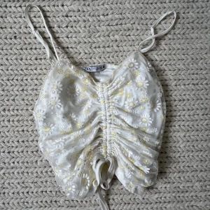 Blommig topp  - Blommig topp med mesh-tyg och knytning. 