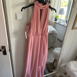 Långklänning  - En superfin klänning som är helt ny med lappar kvar på, den har en kort polokrage med knappar baktill samt en slits nertill och fin öppning vid bröstet. Perfekt till balen bröllop,fest eller dejten! Får inte längre på mig denna därav säljs.Nypris 800