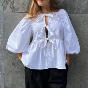 Boii studios topp - Supersöt knytblus från Boii studios! Lappen är avtagen men den är helt ny och aldrig använd🤍 Liknar Ganni toppen som e hypead men för en billigare peng. Köpt för 700kr🌟