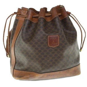 Celine Macadam Bucket bag - Bucket bag från Celine! Mönstret heter Macadam och har nu nyligen relanserats av Celine som Triomphe och har återigen blivit mycket eftertraktat. Axelremmen är justerbar. Stängs igen med snörning.
