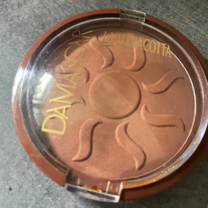 Oanvänt teracotta puder  - Baksidan ser inte så trevlig ut men inget som påverkat puder. Nytt! 