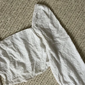 Vit blus - Vit blus med spetsdetaljer och knäppning vid ärmslutet. 