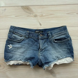 Lågmidjade jeansshorts - Säljer dessa jeansshorts med spetsdetaljer. Strl 27, så passar en S💗Fint skick! Hör av er vid frågor!
