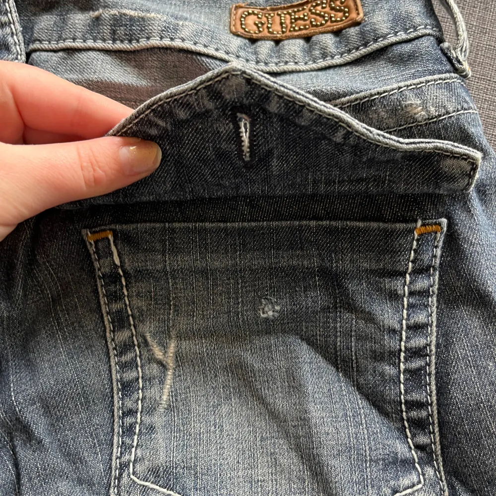 Lågmidjade Jeans med snygga vintage detaljer. Märket ”Guess”  Tyvärr har en av knapparna på ena bakfickan låstnat därav det låga priset (se bild)!  Utländska storlekar men den står som 30 (se bild) skulle nog passa typ 36. Köpare står för frakten💕. Jeans & Byxor.
