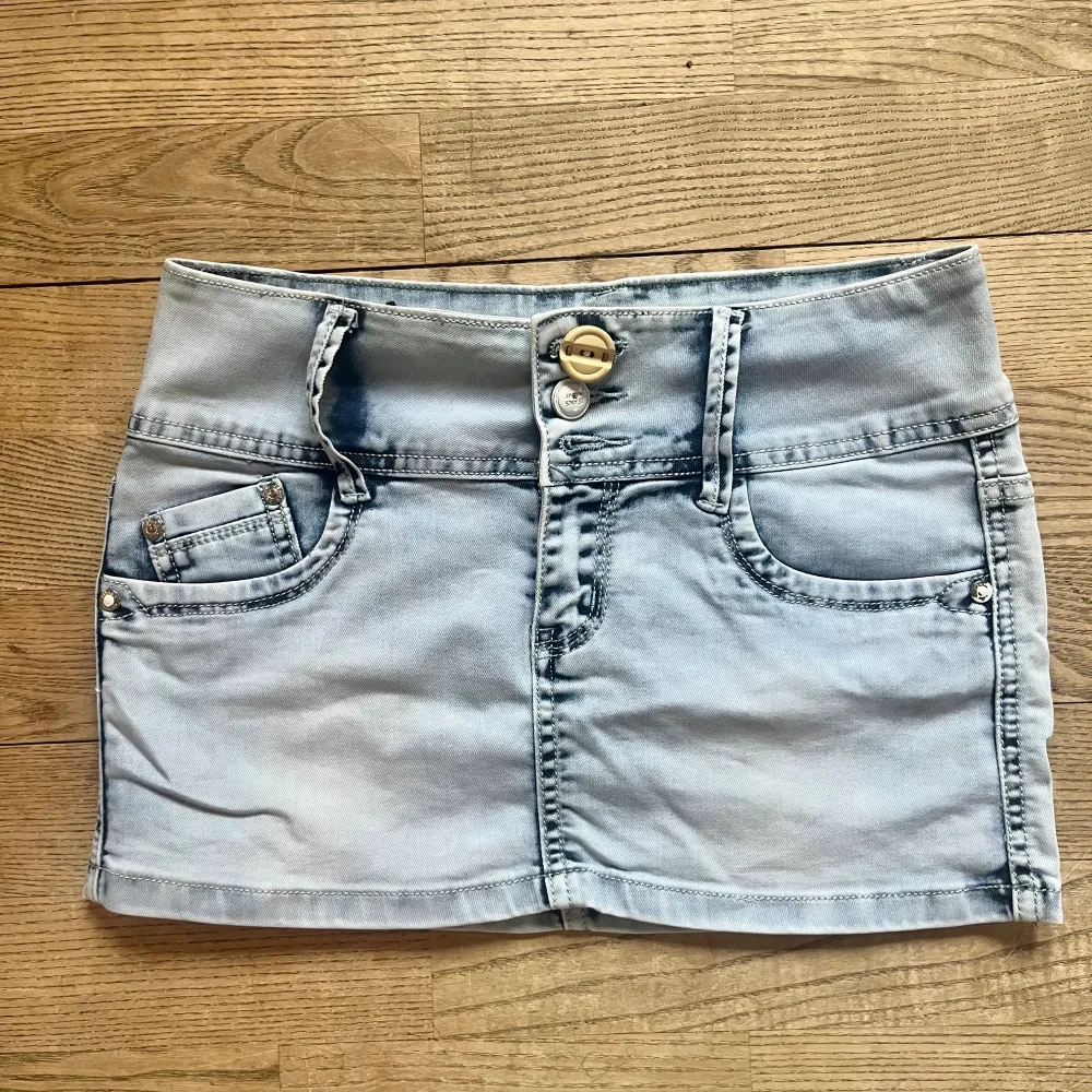 Lågmidjad Jeans kjol, en knapp är sönder men inget man tänker på. Midjemått 33 cm rakt över, längd 27 cm. Köp via köp nu ❤️. Kjolar.