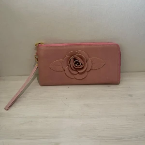 Rosa kuvertväska - Rosa kuvertväska med ros på. Helt ny ! I riktig läder 🩷 längden är 24cm och höjden är 13cm:) för bara 199kr. 