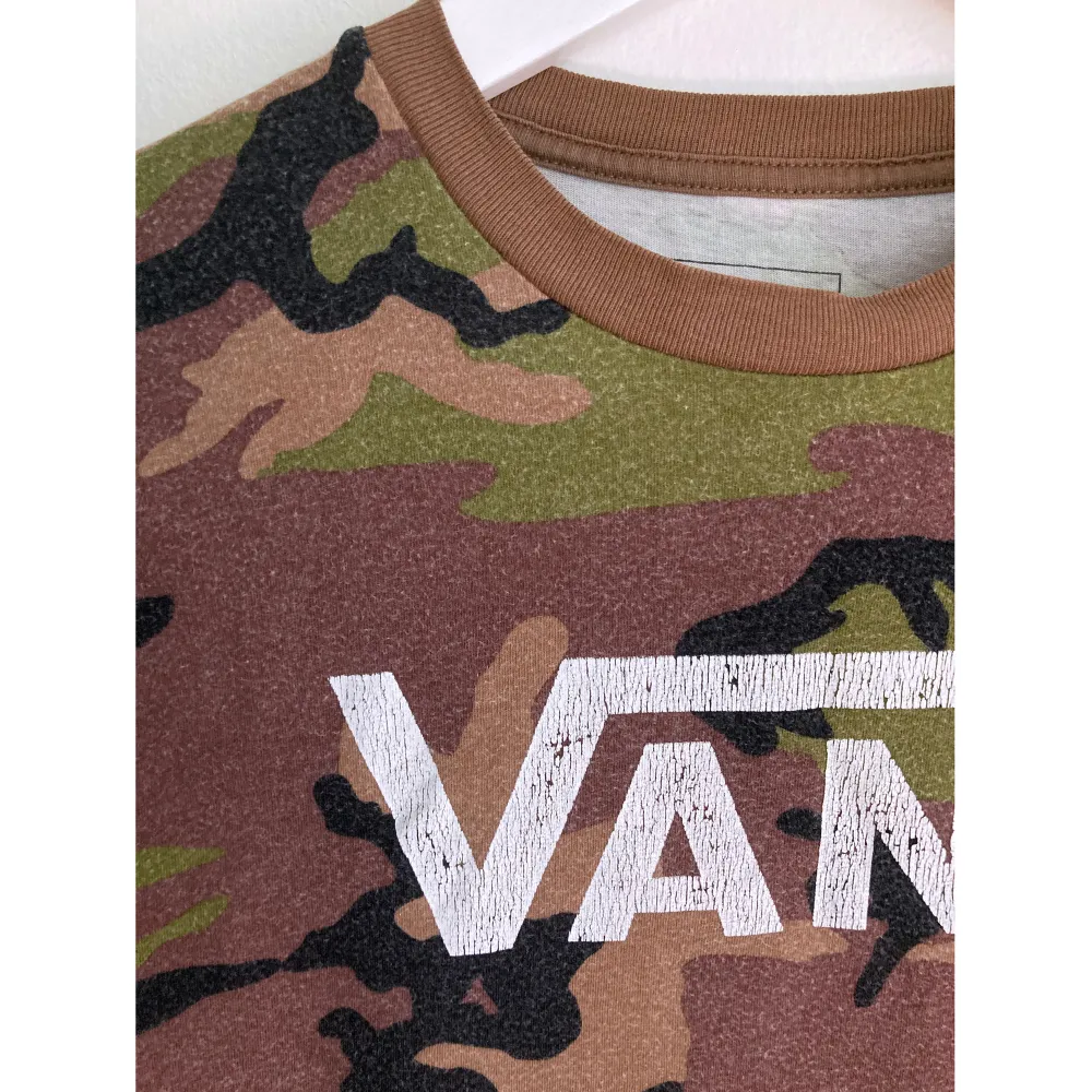 Kamouflagemönstrad bomulls t-shirt med Vans tryck. Väl använt skick. Mått i cm: bröstvidd 46; axelbredd 40; längd fram från axeln 57,5; ärmlängd 20.. T-shirts.