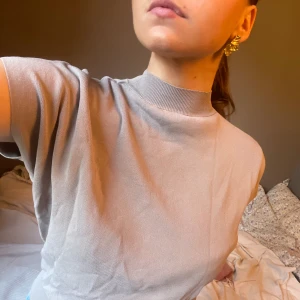 Fin topp polo och tajt i midjan, ljusgrå grå - Fin topp med polo som sitter tajtare i midjan. Ljusgrå/beigeaktig. Står strl M men passar mer S. Så fin till sommaren.