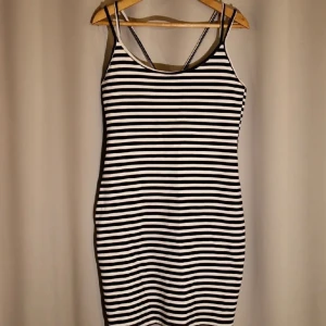 Bodyconklänning  - Randig bodyconklänning med korslagda band i ryggen. Sitter väldigt smickrande! Storlek M. Fint skick.  Kolla gärna in mina andra annonser för samfrakt.  Katt finns i hemmet (allergivänlig ras).