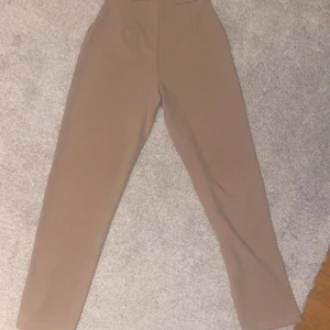 Kostymbyxor  - Ett par beiga kostymbyxor. Aldrig använda då beige färg ej passar mig. Storlek 34