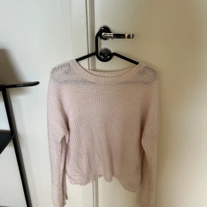 Stickad tröja - Ljusrosa stickad tröja med detaljer i armarna.