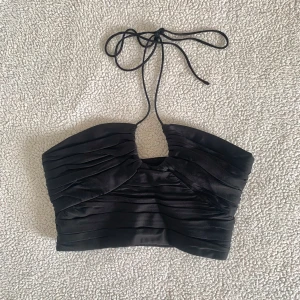 ZARA glansig crop top med rosett - Snygg crop topp från ZARA som knyts vid bysten. Använd i några timmar, utan anmärkningar. Stretch i ryggen.