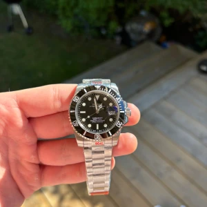 Seiko Black Submariner Mod 40mm - Tja! Har fått in en till Seiko Black Submariner Mod. Helt ny och mycket fin. Tung och gedigen. Om klockan: 904L Stainless Steel. NH35 Automatisk Seiko rörelse. C3 Lume. Sitter på ett oyster armband. Ingår verktyg till att byta länkar!