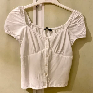 Vit söt gullig topp blus milkmaid coquette korsett rosett smock knappar detaljer stockholmsstil - En söt topp från Bershka i storlek XS. Knapparna går att öppna!
