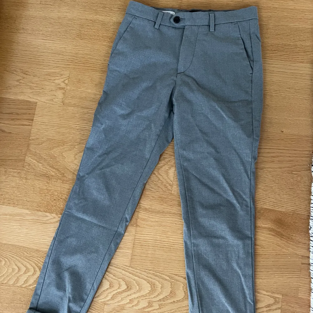 Gråa Kostymbyxor ifrån Jack&Jones i storlek 27/30, använda en gång, skriv för frågor⭐️. Farkut & Housut.