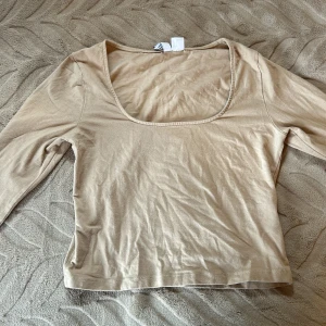 Croped långärmad tröja  - En croped långärmad tröja. Köpt på H&M avdelning divided. I färgen beige. Använd väldigt varsamt. I storleken S.