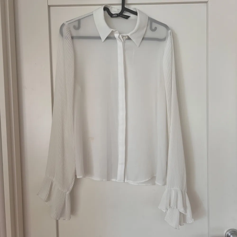 Lätt transparent vit blus från ZARA. Plisserade armar med volang.  Strl. M (passar en S-M). Blusar.