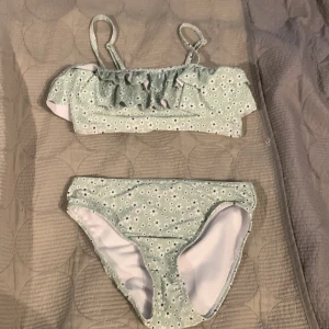 Bikini💗 - Jättefin bikini med mintgrön botten och små vita blommor, volang på toppen och justerbara axelband. Storlek 134/140. 