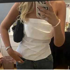 Vit bandeau topp - En väldigt snygg och elegant topp som tyvärr var för liten för mig därav säljer jag vidare. Toppen är från Zara i stolen XS. Den är köpt på Plick, använder bild från tidigare annons.