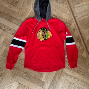 Chicago Blackhawks Hoodie - Tjena! Säljer denna Chicago Blackhawks hoodie i storlek S. Den är köpt i den officiella NHL butiken i New York. Aldrig använd, dvs 10/10 skick. Vid funderingar eller behov av ytterligare bilder, tveka inte att kontakta!