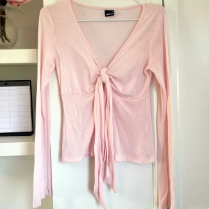 Blus med knytning - Långärmad knyttröja. Färgen rosa. Långärmad modell med knytning i bysten med band som sitter fast i tröjan. Knytningen kan göras vanligt eller som rosett. Jättefint skick. Från GinaTricot. Storlek S. 💗