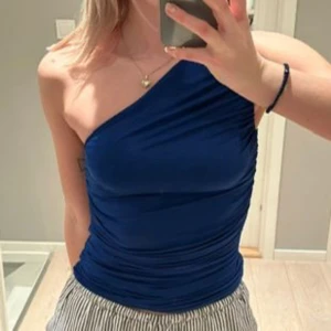 Blå topp  - Blå one shoulder topp, storlek 36, knappt använd 