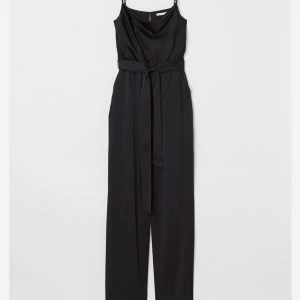 Jumpsuit  - Jumpsuit i satin med raka ben och vattenfallsringning. Dragkedja baktill och justerbara band. Från H&M, i nyskick med prislappen kvar. Nypris var 399 kr. Obs: Knytbältet har tyvärr tappats bort, men kan ersättas med vilket annat bälte som helst.  