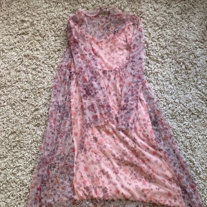 Blommig långklänning från Zara Girls - Säljer en superfin blommig långklänning från Zara Girls. Klänningen är i storlek 140 cm och har ett vackert blommönster i rosa och lila toner. Den är tillverkad i ett tunt och luftigt material som känns väldigt bekvämt att ha på sig. Perfekt för sommarens alla fester och tillfällen! 🌸