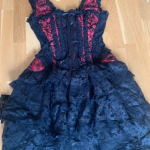 Corset klänning - Svart och röd corset klänning. Storlek XS/S. Har använts 2 gånger, nästan helt ny och oanvänd. Kan skicka fler bilder om det begärs! Orginal pris var 1900 kr.